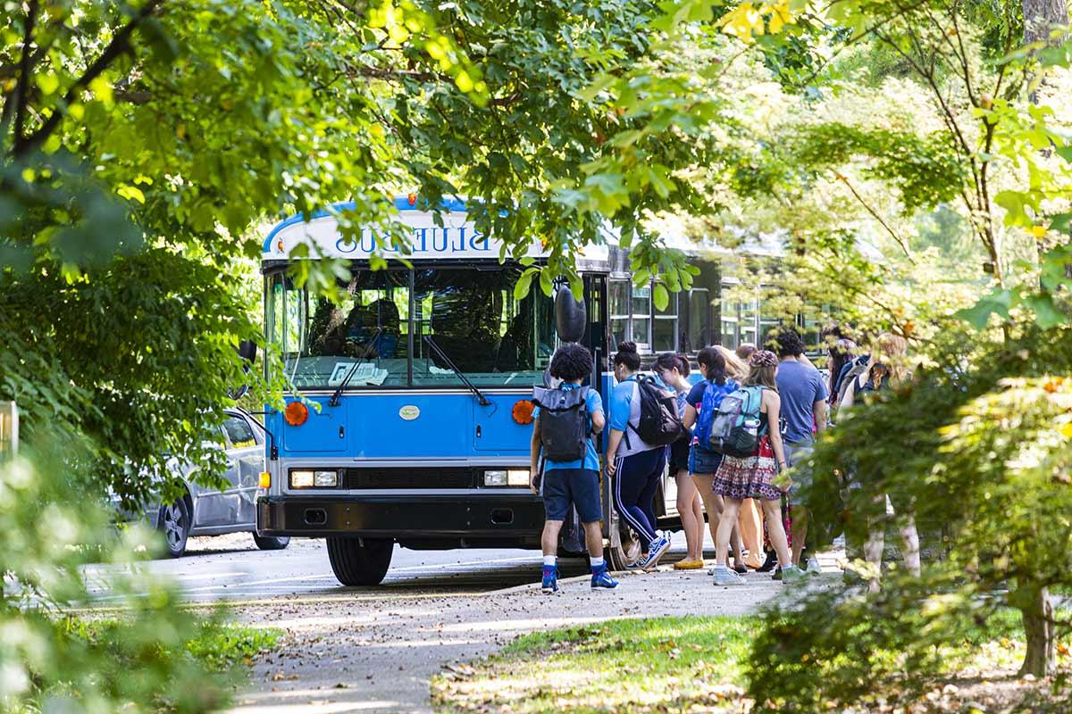students approaching the blue bus to head to bryn mawr college